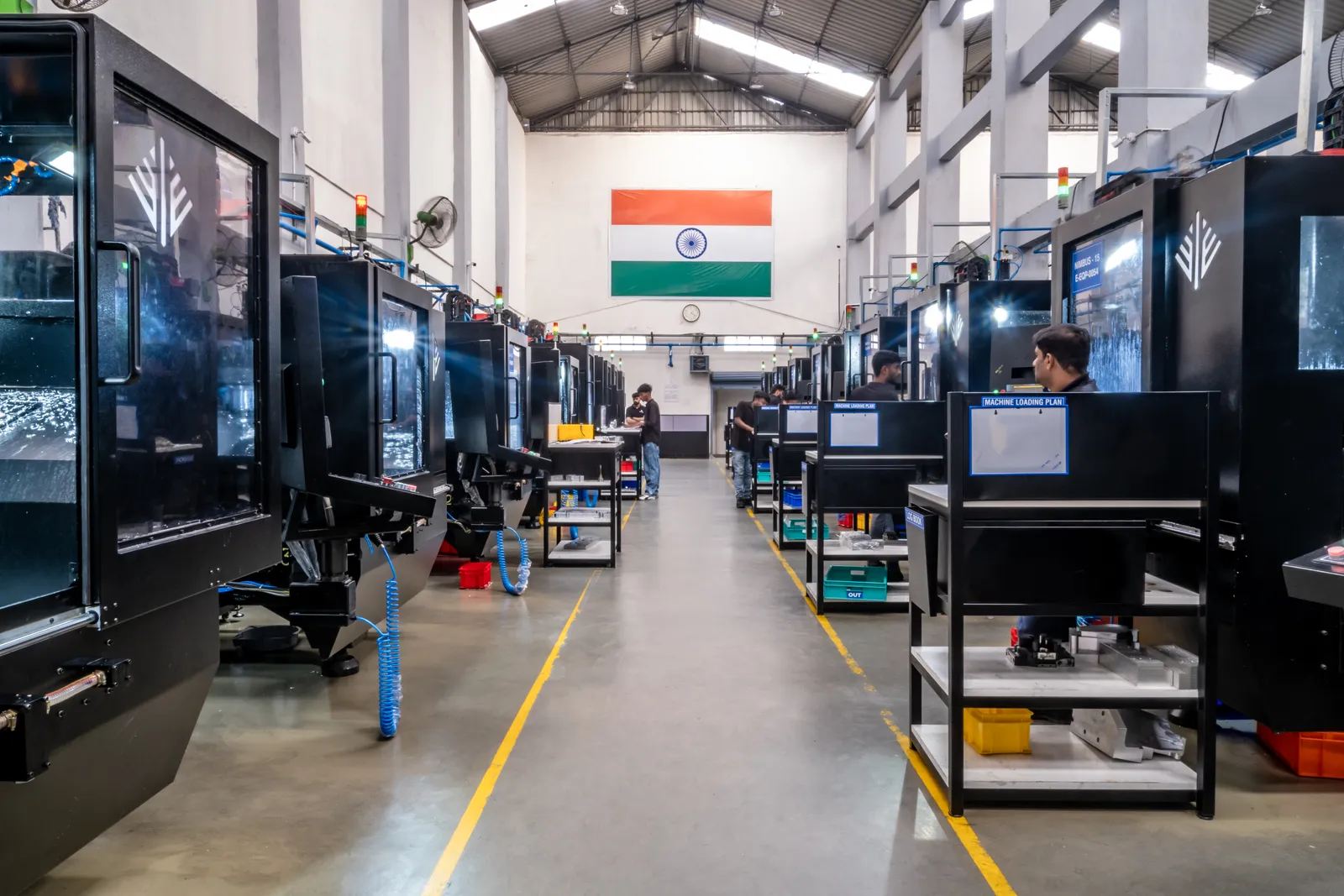 The Ethereal Machines production floor in Bengaluru — rows of CNC platforms under the Indian flag